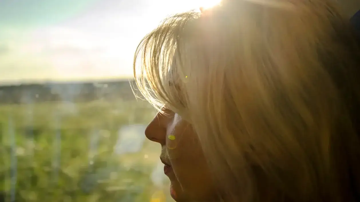 Thoughtful menopause woman seen through reflected light.